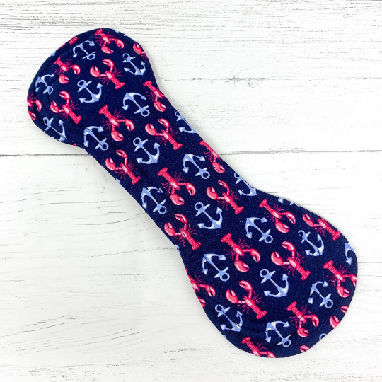 Reusable cloth sanitary pad with navy lobster and anchor pattern. Shown fastened