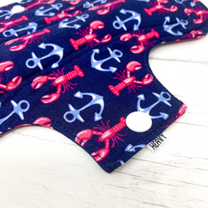 Reusable cloth sanitary pad with navy lobster and anchor pattern. Close up view of fastening