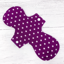 Load image into Gallery viewer, Large reusable sanitary towel or cloth pad in purple cotton fabric with white star pattern. Back view. 
