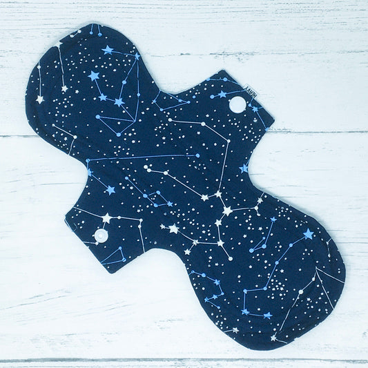 11" Reusable menstrual pad with pattern of constellations on a navy background.